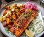 Salmón al horno con verduras doradas y limón en una bandeja