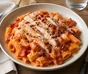 Rigatoni con salsa cremosa de tomate, pollo a la parrilla, beicon crujiente y parmesano rallado
