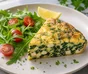 Frittata de espinacas y feta cortada en porciones con rúcula, tomates cherry y perejil rizado